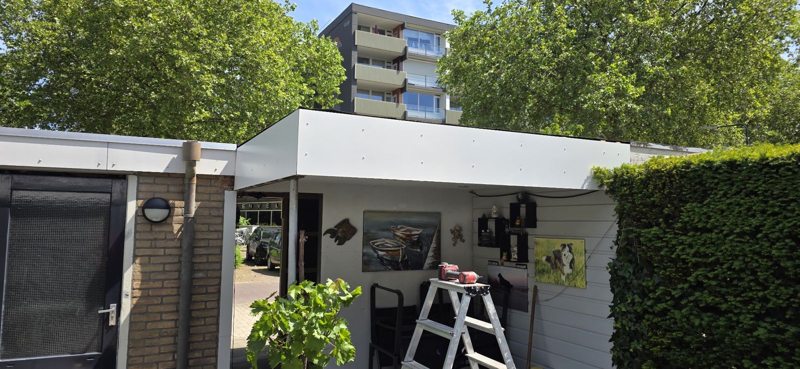 Nieuwe witte boeiboorden langs de dakrand van een berging met overkapping